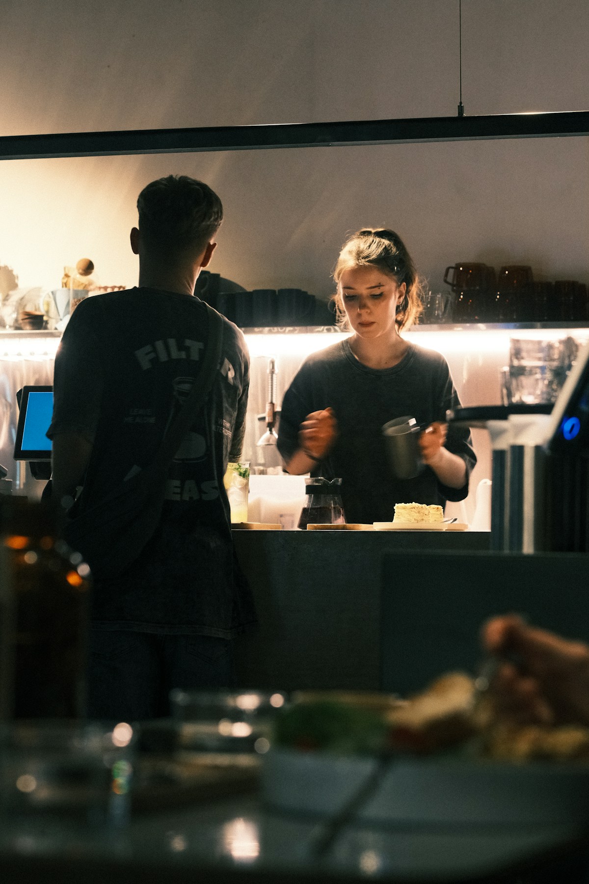A barista serving a customer during a normal day at a café
